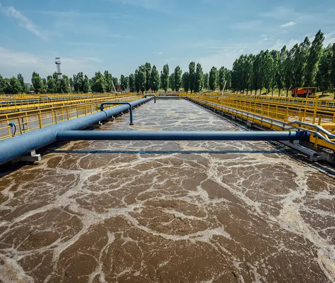 Industrial wastewater treatment facility Aeration basin with churning brown wastewater at a treatment plant