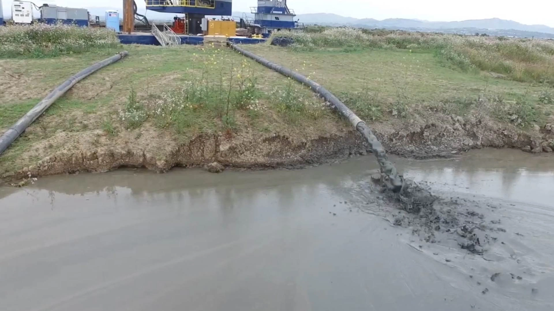 Slurry pump in action with solids Solids flowing out of slurry pump hose